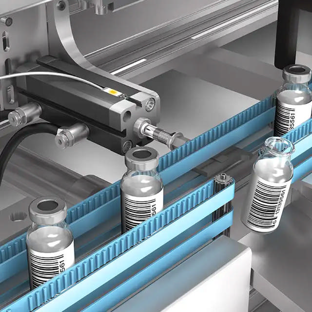 Ein Zylindersensor erfasst die Endlage des Pneumatikzylinders, der die Vials auf dem Förderband vereinzelt oder stoppt. Der Sensor detektiert den Kolbenmagneten kontaktlos und sorgt für eine präzise, wiederholgenaue Positionserkennung im Takt der Anlage. 